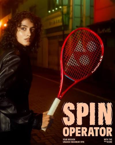 Person hält roten Yonex VCORE Tennisschläger bei Nacht, Marketingmotiv mit Schrift Spin Operator.